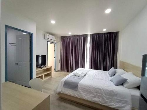 um quarto com uma cama grande e uma televisão em El Huq em Banguecoque