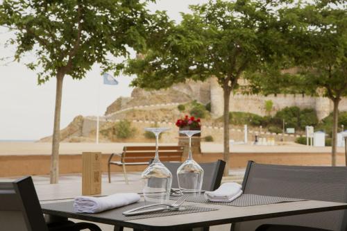 a table with two wine glasses on top of it at Hotel Diana in Tossa de Mar