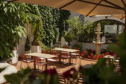 a patio with tables and chairs and a fountain at Hotel Diana in Tossa de Mar