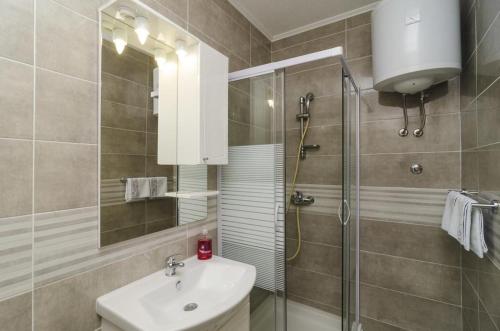 ein Bad mit einem Waschbecken und einer Dusche in der Unterkunft Apartments by the sea Sobra, Mljet - 4889 in Babino Polje