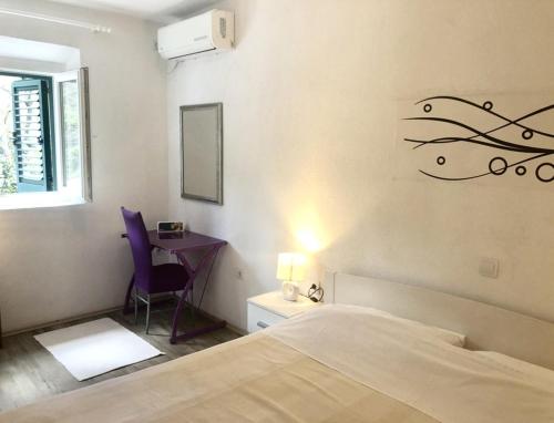 a bedroom with a bed and a desk with a lamp at Apartments by the sea Kozarica, Mljet - 4950 in Kozarica