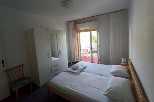 a bedroom with a large white bed with a mirror at Apartments by the sea Supetarska Draga - Donja, Rab - 5042 in Supetarska Draga