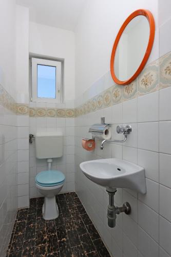 a bathroom with a toilet and a sink and a mirror at Apartments with parking space Supetarska Draga - Donja, Rab - 4966 in Rab