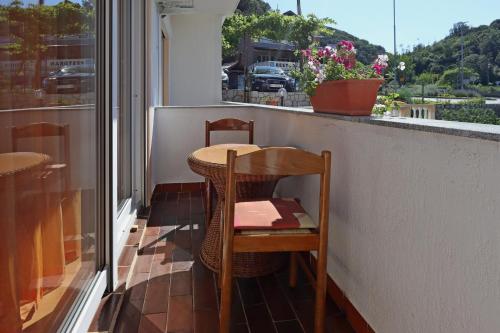 a table and chair on a balcony with a window at Apartments with parking space Supetarska Draga - Donja, Rab - 4966 in Rab