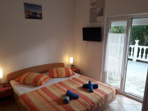 a bedroom with a bed with two blue pillows on it at Apartments with a parking space Palit, Rab - 4990 in Rab