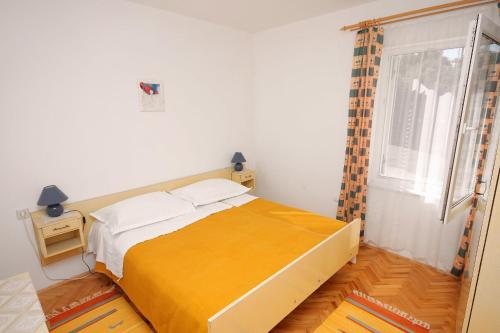 a bedroom with a large bed and a window at Apartments with parking space Banjol, Rab - 4956 in Rab