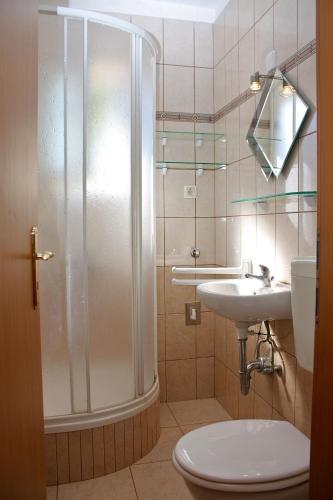 a bathroom with a shower and a toilet and a sink at Apartments with parking space Banjol, Rab - 4956 in Rab