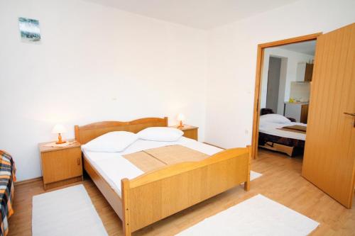 sypialnia z drewnianym łóżkiem i lustrem w obiekcie Apartments with a parking space Kampor, Rab - 5029 w mieście Kampor