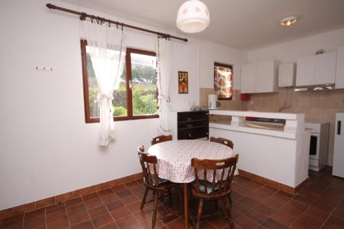 eine Küche mit einem Tisch und Stühlen im Zimmer in der Unterkunft Apartments by the sea Supetarska Draga - Gonar, Rab - 4989 in Supetarska Draga