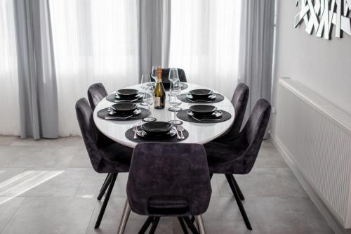 a dining room table with black chairs and a white table at Apartments with parking space Banjol, Rab - 5041 in Rab