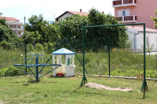 a swing set in a yard with a gazebo at Apartments with a parking space Lopar, Rab - 5019 in Lopar