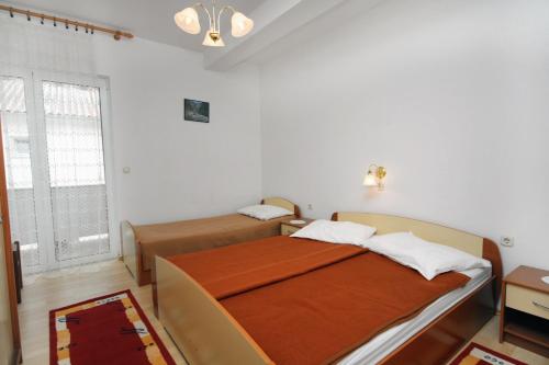 a bedroom with two beds and a window at Apartments by the sea Barbat, Rab - 4993 in Barbat na Rabu