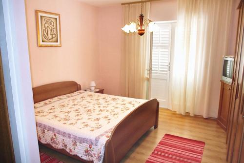 Un dormitorio con una cama en una habitación con ventana. en Apartments by the sea Barbat, Rab - 4978, en Barbat na Rabu