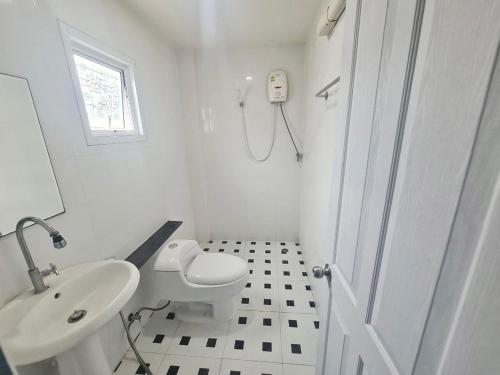 uma casa de banho branca com um WC e um lavatório em El Huq em Banguecoque