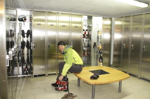 a man sitting on a bench in a wine room at Hotel Le Alpi in Livigno