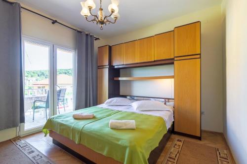 1 dormitorio con 1 cama grande y ventana grande en Apartments and rooms with parking space Jelsa, Hvar - 4028, en Jelsa