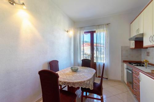 a kitchen with a table with chairs and a window at Apartments and rooms with parking space Jelsa, Hvar - 4028 in Jelsa