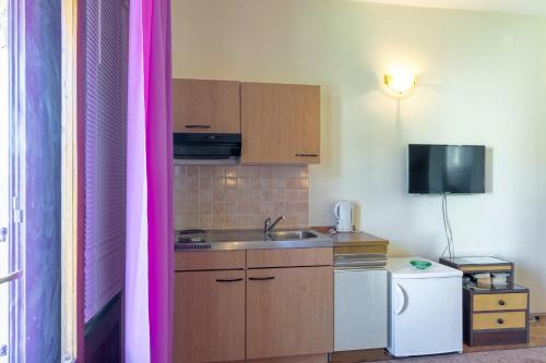 a small kitchen with a sink and a refrigerator at Apartments and rooms with parking space Jelsa, Hvar - 4028 in Jelsa