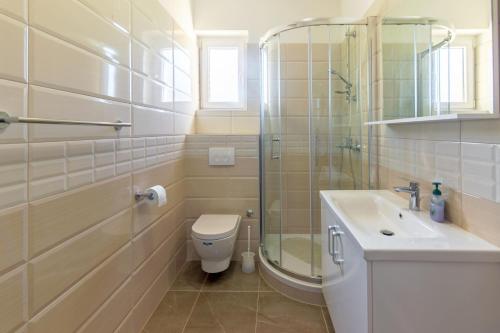 y baño con aseo, lavabo y ducha. en Apartments and rooms with parking space Jelsa, Hvar - 4028, en Jelsa