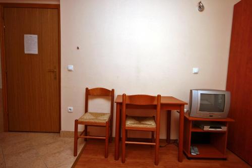 een kamer met een tafel en twee stoelen en een televisie bij Apartments by the sea Duce, Omis - 4852 in Duće