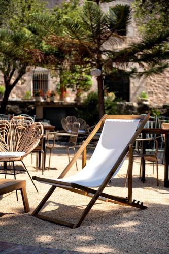 una poltrona bianca seduta accanto ad alcune sedie di La Mer Hotel a Cabrera de Mar