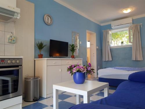 a blue room with a bed and a table with flowers at Apartments with parking space Banjol, Rab - 5071 in Rab