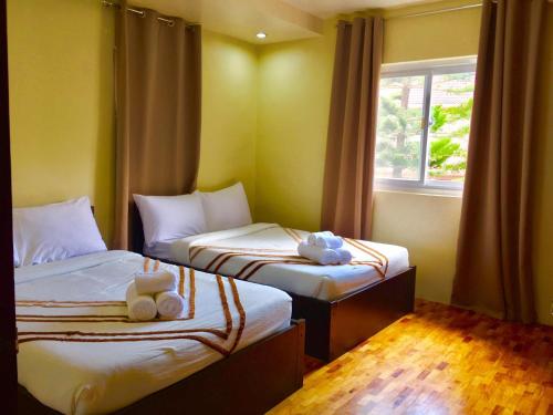 a room with two beds and a window at Elliannah Pines Hotel in Baguio