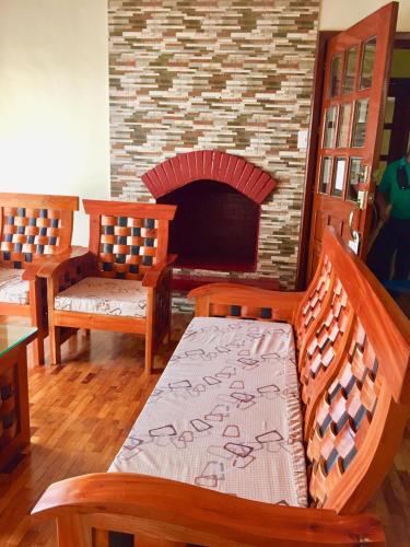 a room with three wooden benches and a fireplace at Elliannah Pines Hotel in Baguio