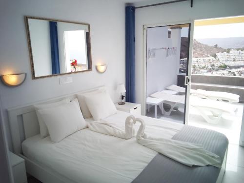 プラヤ・デル・クーラにあるCasa Heike at Monseñorのベッドルーム1室(白鳥のベッド1台付)
