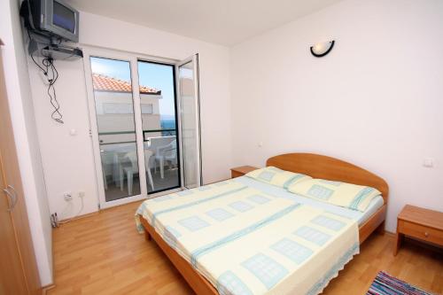 a bedroom with a bed and a large window at Apartments by the sea Balica Rat, Omis - 4868 in Čelina