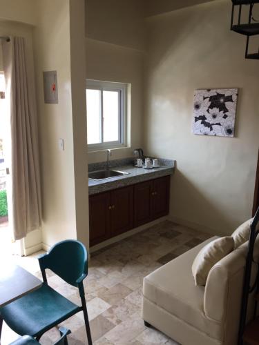 a living room with a couch and a sink at Elliannah Pines Hotel in Baguio
