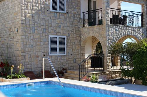 Seaside apartments with a swimming pool Rogac, Solta - 5183 في Grohote: مسبح امام مبنى