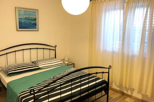 a bedroom with a bed and a large window at Seaside apartments with a swimming pool Rogac, Solta - 5183 in Grohote