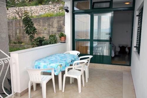 un tavolo e sedie sul balcone di una casa di Apartments with a parking space Drvenik Gornja vala, Makarska - 4890 a Drvenik