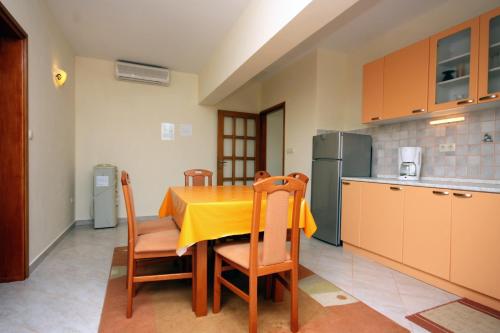 a kitchen with a table with a yellow table cloth at Apartments with a parking space Kampor, Rab - 5018 in Rab