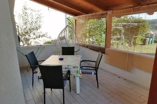 a patio with a table and chairs on a balcony at Apartments for families with children Lopar, Rab - 5024 in Lopar