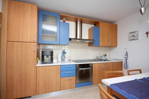 Una cocina con gabinetes azules y un fregadero. en Apartments and rooms by the sea Barbat, Rab - 5068, en Rab