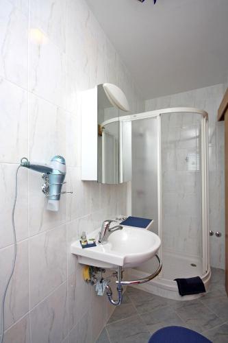 a bathroom with a sink and a shower at Apartments and rooms by the sea Barbat, Rab - 5068 in Rab