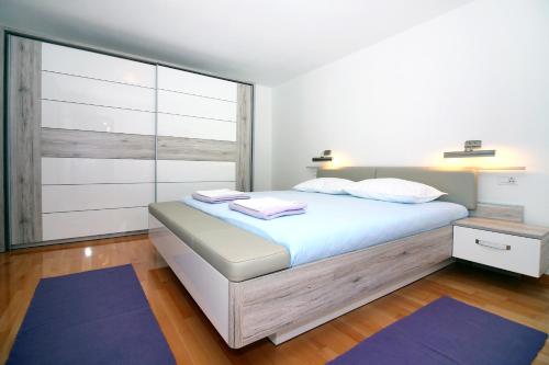 een slaapkamer met een bed en een groot raam bij Apartments and rooms by the sea Tisno, Murter - 5106 in Tisno