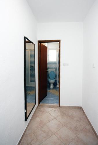 a bathroom with a toilet and a mirror at Apartments and rooms with parking space Barbat, Rab - 5070 in Rab