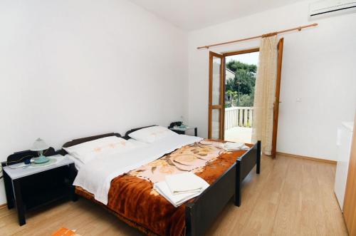 um quarto com uma cama grande e uma janela em Apartments and rooms by the sea Cove Saplunara, Mljet - 4907 em Saplunara
