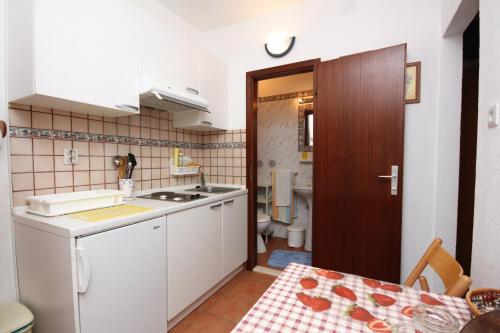 małą kuchnię ze zlewem i toaletą w obiekcie Family friendly apartments with a swimming pool Maslinica, Solta - 5180 w mieście Maslinica