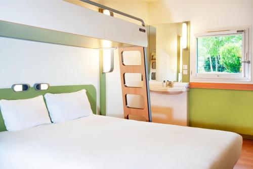een slaapkamer met een bed, een wastafel en een stapelbed bij ibis budget Flers Grands Champs in Flers