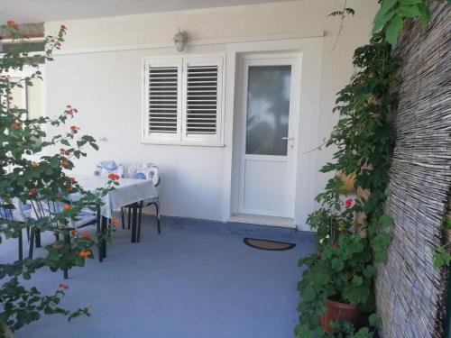 um pátio com uma mesa e uma porta branca em Apartments by the sea Cove Saplunara, Mljet - 4896 em Maranovići