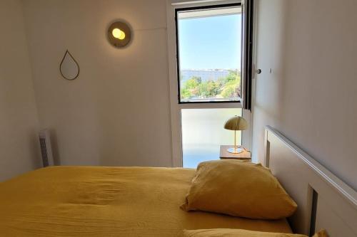 a bedroom with a bed with a large window at Superbe appartement Arcachon in La Teste-de-Buch