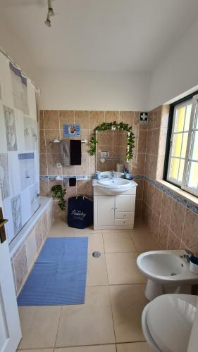 ein Badezimmer mit zwei Waschbecken und einer Badewanne und einem Spiegel in der Unterkunft Casa Branca Holiday Resort in Salir