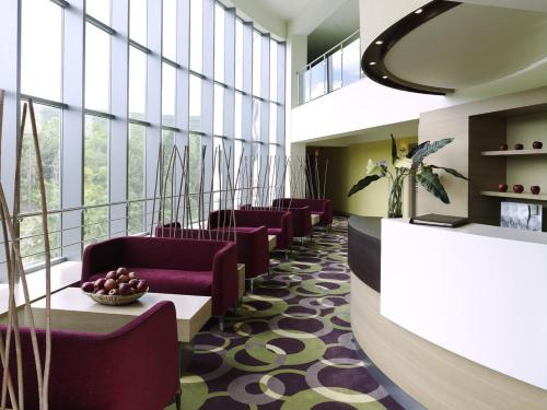a waiting room with purple chairs and windows at Flamingo Grand Hotel & Spa in Albena