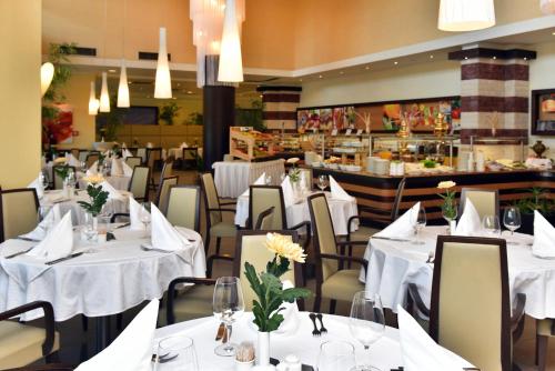 a dining room with tables and chairs with white table cloth at Flamingo Grand Hotel & Spa in Albena