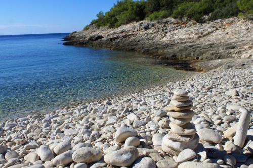 a stack of rocks on a rocky beach near the water at Apartments with parking space Rukavac, Vis - 8839 in Rukavac