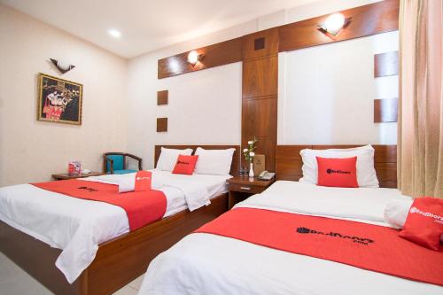 a bedroom with two beds with red and white sheets at Phuong Thuy Hotel Thu Duc near QL13 in Ho Chi Minh City